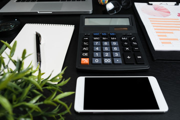 Black desk with computer graph and calculator