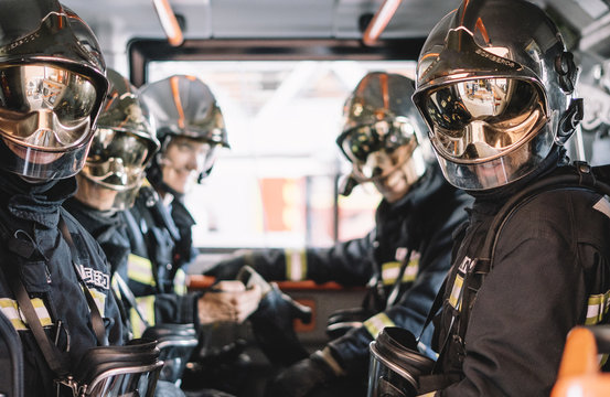 unrecognizable firemen with helmet in an emergency vehicle