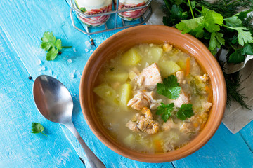 Soup with salmon (ears) and open pies with red fish on the kitchen wooden background. Russian cuisine. Copy space.