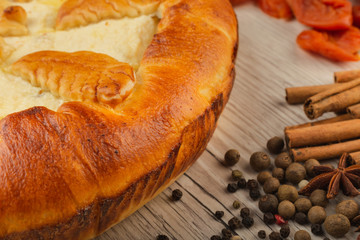 Home-made curd cake on a wooden background with ingredients.