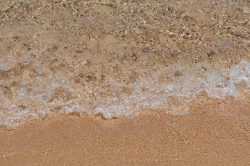 Fototapeta na wymiar The sea wave runs on the sand