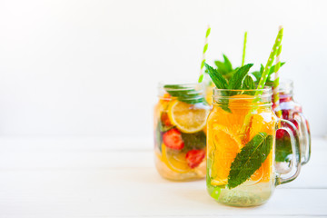 Homemade iced lemonade with mint, summer fruits and berries in a mason jar. Copy space background
