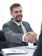 closeup .handshake of business partners above the Desk