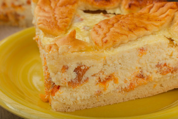 Cut homemade curd cake on a wooden background with ingredients.