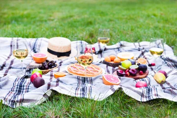 Cercles muraux Pique-nique Picnic background with white wine and summer fruits on green grass, summertime party