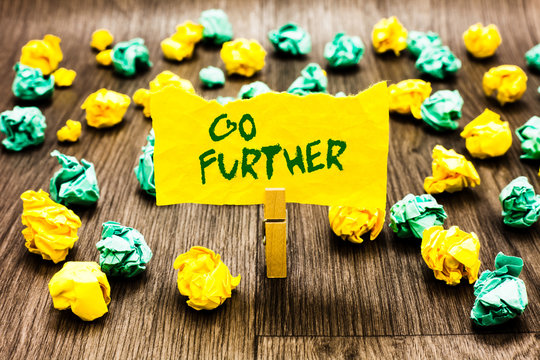 Writing note showing Go Further. Business photo showcasing To move to a greater distance or overcome your limitations Clothespin holding yellow note paper crumpled papers several tries.