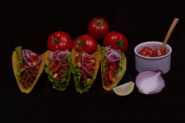 National spicy salsa tomatoes sauce for delicious tortilla tacos with green lettuce, cutting lime, onion and ripe red vegetable lying on tray.