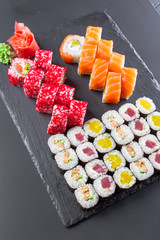 Japanese restaurant, sushi roll on black slate plate.