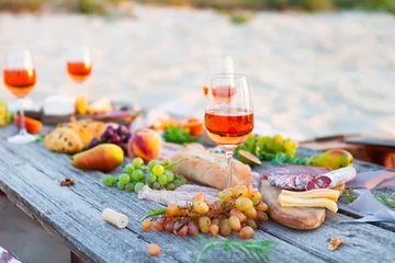 Crédence de cuisine en verre imprimé Pique-nique Picnic on beach at sunset in boho style. Romantic dinner, friends party, summertime, food and drink concept