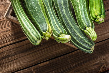 Green zucchini, organic vegetables. Farm fresh courgette in a box, overhead.