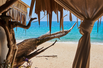 Panoramic view through  terrace bar made of weathered wood near tropical coastline. Azure water of ocean on the background.