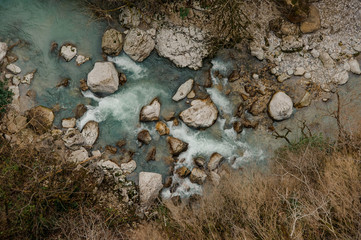 Top view on the mountain river flowing among the rocks and trees