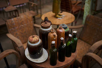 Various vintage objects and furniture for sale at a indoor flea market. View of a display full of interesting old things for sale. Many groups of vintage assorted second-hand objects.