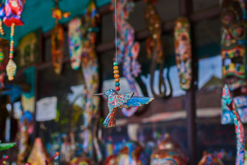 Souvenir background. Travel and tourism concept. Hanging handicraft decoration wooden carved toys. Art and craft market. Display of handicraft decoration in the open market. Selective focus.