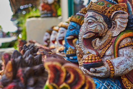 Typical souvenir shop selling souvenirs and handicrafts of Bali at the famous Ubud Market, Indonesia. Balinese market. Souvenirs of wood and crafts of local residents. Wooden statues made from wood.