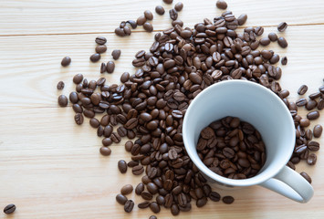 Coffee beans in a coffee cup on wooden background.