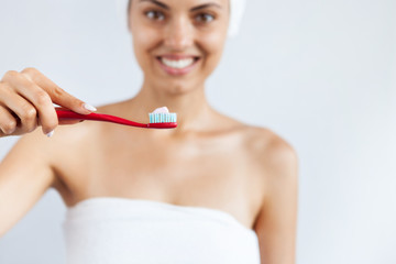 Smiling happy young woman with healthy teeth holding a tooth brush. Clean beauty and healthy concept