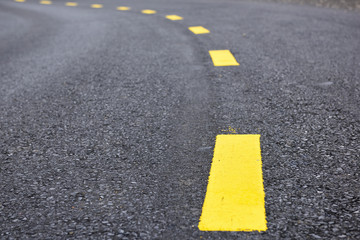 Closeup asphalt road with marking lines for giving directions, traffic lines concept