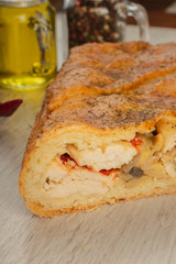 Meat pie on a wooden background with ingredients.