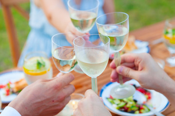 Family outdoor dinner in the garden in summer at sunset. Picnic food and drink concept