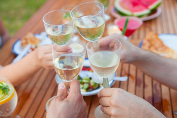 Family outdoor dinner in the garden in summer at sunset. Picnic food and drink concept