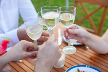 Family outdoor dinner in the garden in summer at sunset. Picnic food and drink concept