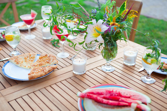 Family outdoor dinner in the garden in summer at sunset. Picnic food and drink concept
