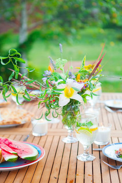 Family outdoor dinner in the garden in summer at sunset. Picnic food and drink concept