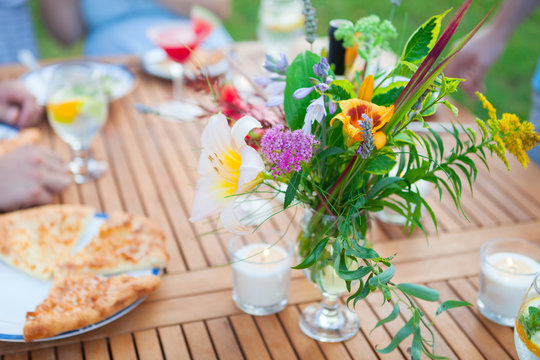 Family outdoor dinner in the garden in summer at sunset. Picnic food and drink concept