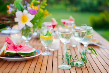 Crédence de cuisine en verre imprimé Pique-nique Family outdoor dinner in the garden in summer at sunset. Picnic food and drink concept