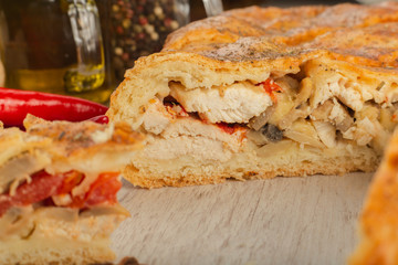 Meat pie on a wooden background with ingredients.