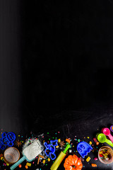 Halloween holiday baking background, with sugar powder, forms for baking, flour, rolling pin, ingredients and spices. on black background top view copy space for text