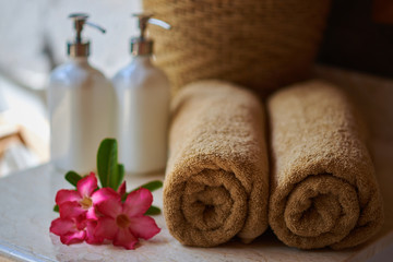 Obraz na płótnie Canvas Beautiful composition of spa treatment. Spa towels and flowers. Relaxing spa resort composition. Beauty concept with spa products set. Spa, service hotel and resort concept.