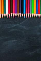 Back to School concept. Color pencils on blackboard background. Close up, flat lay, copy space, top view