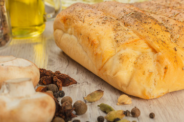 Pie with cabbage and mushrooms on a wooden background with ingredients.