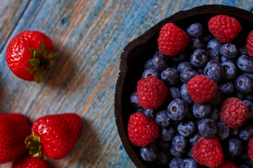 Fresh sweet blueberry, raspberry, strawberry and lemon. Dessert healthy food. Group of ripe juicy organic berries. Healthy raw summer diet. Delicious nature vegetarian ingredient, antioxidants.