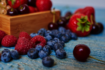 Berries closeup mix  strawberries, red currants, white currants, black currants, cherries, blueberries on wooden table. Selective focus.