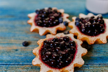 Close-up of mouth-watering tartlets are on the table, the cook is going to serve them with fresh berries