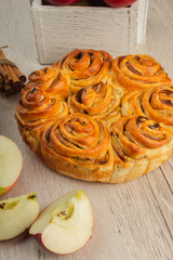 Pie with apples and cinnamon on a wooden background with ingredients.