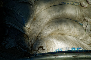 Heap of white flax sack with cement in shadow