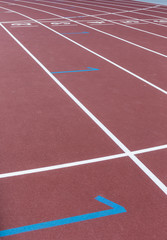 Red sport track for running on stadium starting marks. Running healthy lifestyle concept. Sports background abstract texture