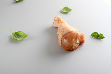 Chicken drumstick in marinade on a light background