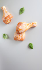 Chicken drumstick in marinade on a light background