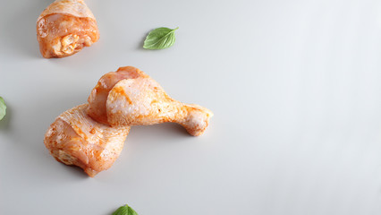 Chicken drumstick in marinade on a light background