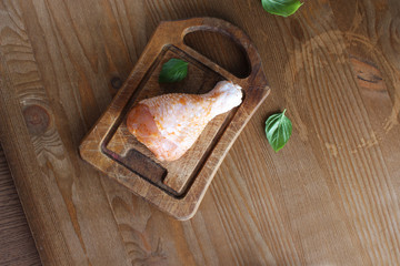 Chicken drumstick in marinade on a wooden background
