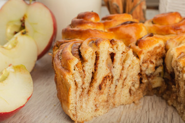 Pie with apples and cinnamon on a wooden background with ingredients.