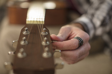 Close-up of man's hand tuning guitar
