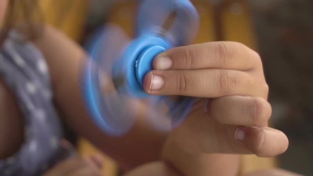 the spinner spins in the girl's hand slow motion