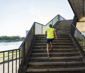 Young athlete jogging up stairs in the city