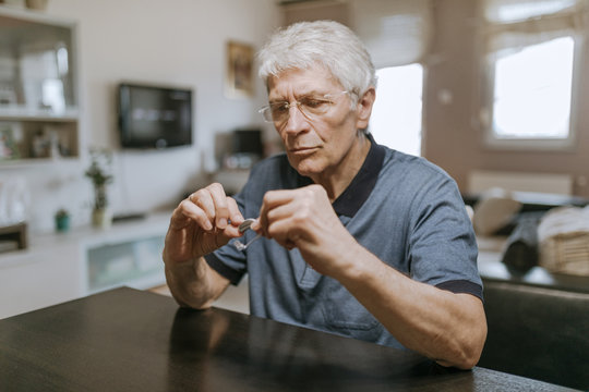 Senior Man Examining Hearing Aid